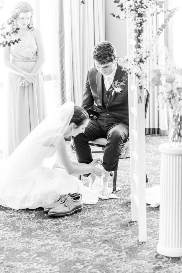 Bride washing groom's feet for foot washing ceremony
