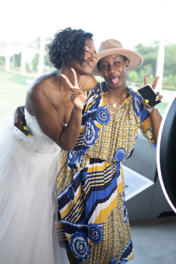 bride and wedding guest posing in photo booth